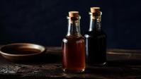 Bottles of patis and soy sauce on a wooden surface